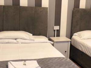 克罗伊登水晶洛奇酒店的客房设有两张床和一个带床罩的床头柜。