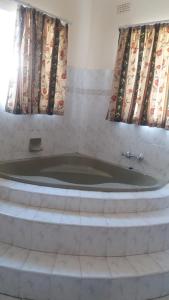 布拉瓦约Tshulu Tsha Nabe B&B的带浴缸的客房,设有2扇窗户