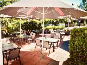 巴贝Hotel Villa Fröhlich的一个带桌椅和遮阳伞的庭院