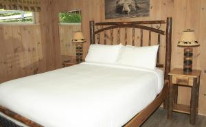 吉尔福特Belknap Point Inn的一间卧室配有一张大床和木制床头板