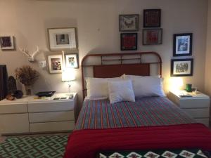 迈阿密The Wild Rose的一间卧室配有一张床,墙上挂着一些图片