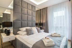克拉科夫Crystal Luxury Apartments Rakowicka 22H的一间卧室配有一张大床和毛巾