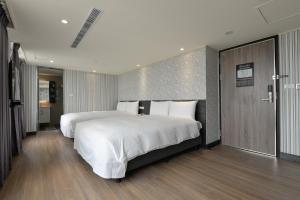 台中市香富大饭店的一间铺有木地板的大卧室,配有一张白色的大床