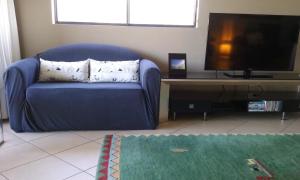 楠巴卡黑兹oceanview 6 with rooftop terrace & spa的客厅设有蓝色沙发,配有平面电视。