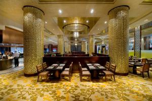北京朝林松源酒店的大堂内的餐厅,配有桌椅