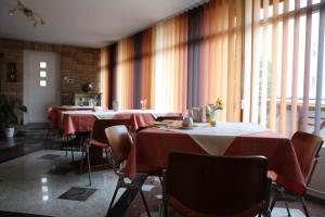 凯奇凯梅特Barokk Antik Guest Hause的一间带桌椅和红色桌布的用餐室