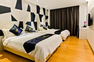 马六甲莫克利精品酒店的酒店客房设有两张床和电视。