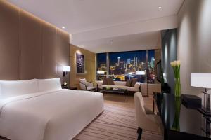 重庆重庆尼依格罗酒店的一间带白色大床的卧室和一间客厅