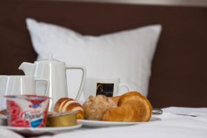 Uzwil乌兹维尔酒店的床上一盘面包和羊角面包