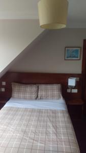 爱丁堡剑桥酒店的一间卧室配有一张大床和木制床头板