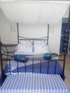 拉康提内勒Les Mouettes的一张带蓝色和白色床单及枕头的床