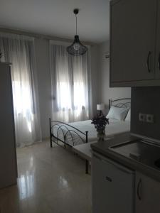 Áyios AndóniosProkymaia Apartment 2的一间卧室配有一张床,厨房配有窗户