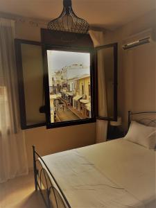 Áyios AndóniosProkymaia Apartment 2的一间卧室设有一张床和一个大窗户