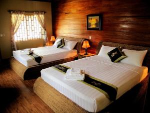 白马市阿特马兰度假村的配有木墙的酒店客房内的两张床
