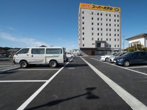 磐城Super Hotel Fukushima Iwaki的停车场,停车场停在大楼前