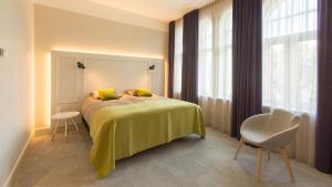 维尔扬迪Park Hotel Viljandi的一间卧室配有一张床、一把椅子和窗户。