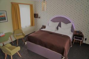 开姆尼茨Themenhotel 50's Ville Motel的卧室配有1张床、1张桌子和1把椅子
