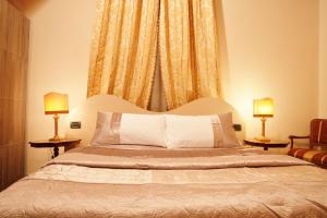 卢卡Lucca Relais的一间卧室配有一张大床和两盏灯