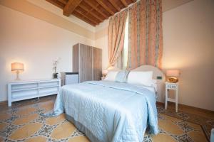卢卡Lucca Relais的一间卧室配有一张带蓝色棉被的床
