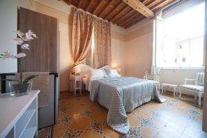卢卡Lucca Relais的一间卧室设有一张床和一个大窗户