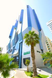 阿布扎比Nehal Hotel的前面有棕榈树的建筑