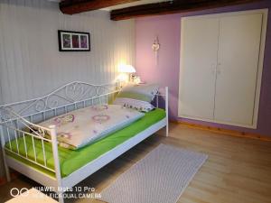 HausenFerienhaus vom Bahratal的卧室配有一张带绿毯的白色床