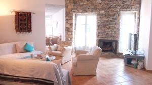 KóstosGuesthouse Casa De La Roca , Kostos , Paros的客厅配有白色家具和石制壁炉