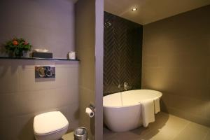 都柏林亚历克斯酒店的浴室配有白色浴缸和卫生间。