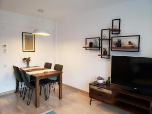 布加勒斯特Urban Nest Apartment的一间带桌椅和电视的用餐室