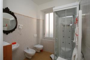 斯坎诺罗马酒店的带淋浴、卫生间和盥洗盆的浴室