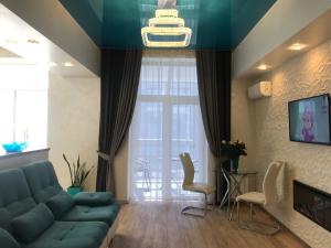 哈尔科夫Luxury Apartment in Downtown, Near River Esplanade的客厅设有蓝色的沙发和大窗户