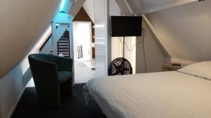 伊普尔Résidence Surmont的配有床和椅子的房间以及楼梯
