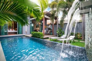 拉威海滩Two bedrooms pool villa at Saiyuan estate的一座房子里一个带瀑布的游泳池