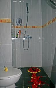 库塔芒加尔印尼酒店的浴室设有卫生间和花卉淋浴,位于地板上