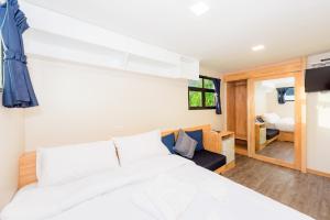 卡伦海滩Memory Karon Resort的一间带白色大床的卧室和一间房间