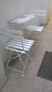 波尔图Loft Mártires的客房内的2把白色椅子和1张桌子