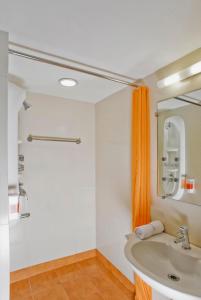 艾哈迈达巴德Ginger Ahmedabad Vastrapur的浴室设有水槽和橙色淋浴帘