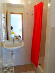 SarródJúlia Vendégház Sarród的浴室设有水槽和红色的淋浴帘