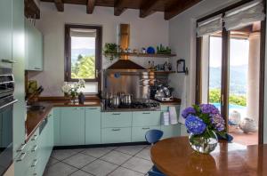 梅纳Villa Eva的厨房配有蓝色橱柜和花瓶桌子