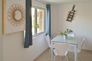拉蒙塔涅L'Estampe的一间带桌子和白色椅子的用餐室