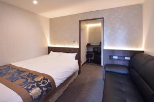 京都UU Inn Kyoto的一间卧室配有一张床、镜子和一张沙发
