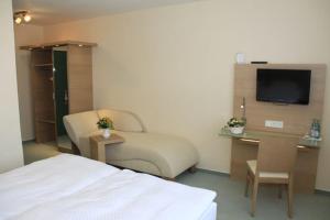 文斯托夫布鲁姆威曼妮酒店的酒店客房设有一张床、一张书桌和一台电视机。