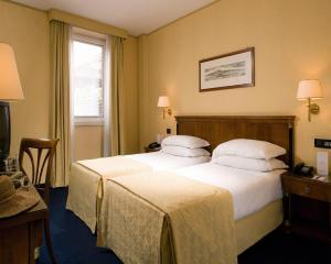 那不勒斯Ramada by Wyndham Naples的酒店客房设有两张床和电视。