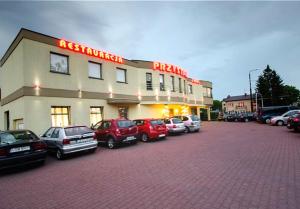 卢布林Restauracja Hotel Przystan的酒店门前设有停车场,可停放汽车