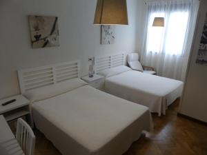 马德里美洲旅馆的酒店客房,配有两张床和椅子
