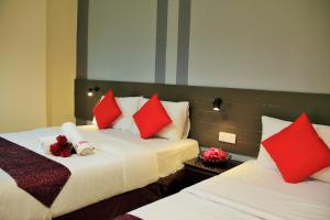瓜拉雪兰戈巴西畔纳邦（堪萨斯州植物园）太阳之星酒店的酒店客房 - 带两张带红色枕头的床