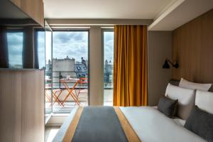 巴黎巴蒂诺勒美居酒店17的酒店客房设有一张床和一个大窗户