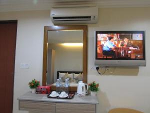 吉隆坡萨弗里酒店的一间墙上配有电视的房间,配有桌子