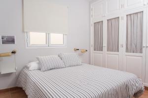 阿列塔Modern home with Ocean View的白色卧室配有带条纹床单的床