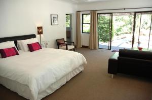 豪特湾The Tarragon的卧室配有一张白色的大床和一张沙发。